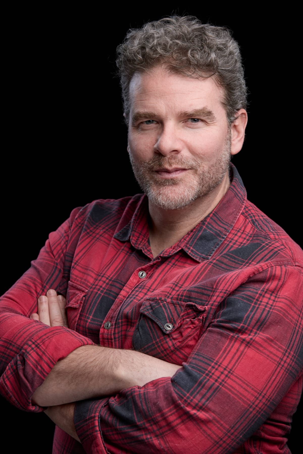 Retrato de Daniel Huarte con camisa de cuadros y mirada directa, book actoral en Madrid