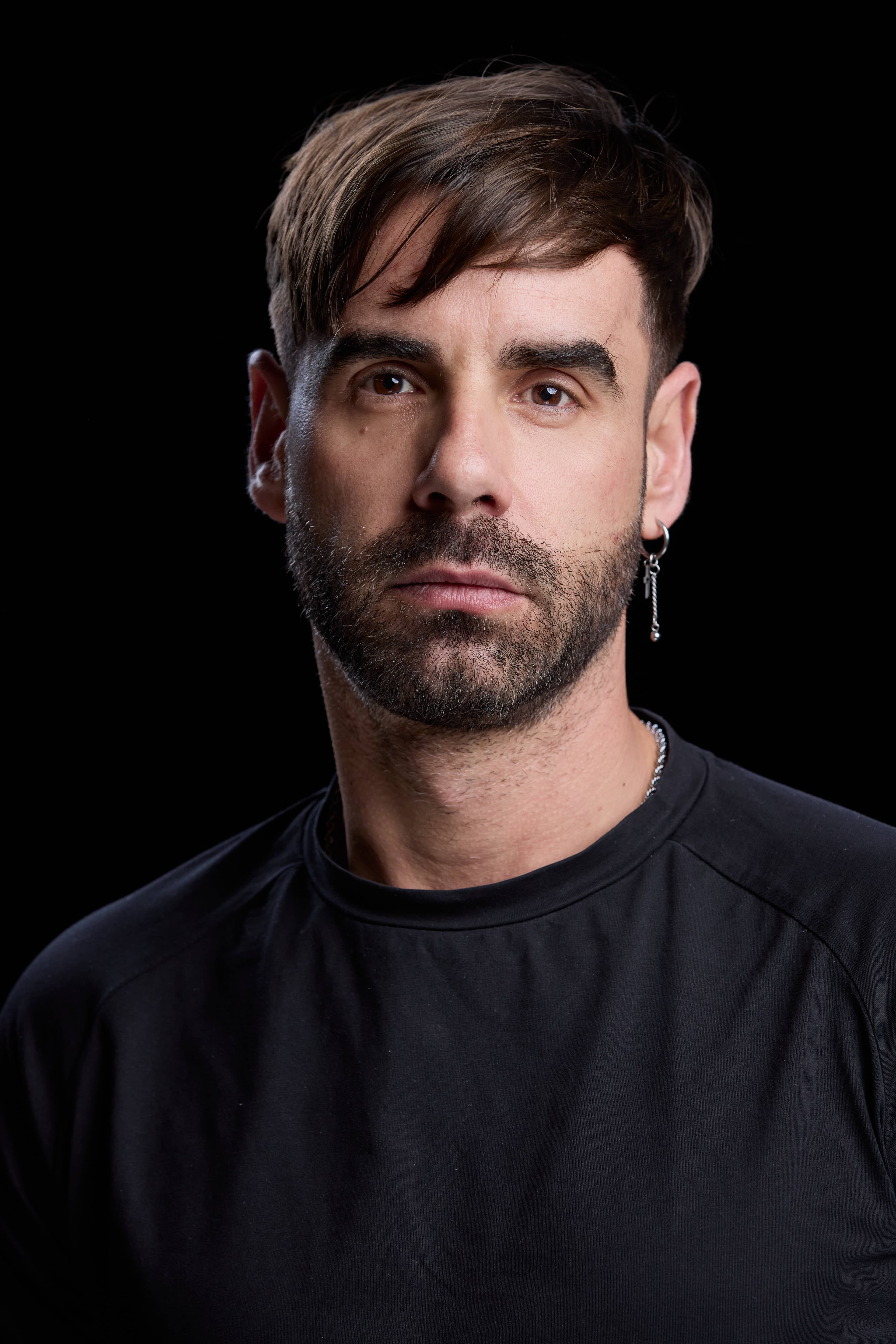 Retrato limpio de David Carrillo con camiseta negra y mirada directa a cámara, book actoral en Madrid