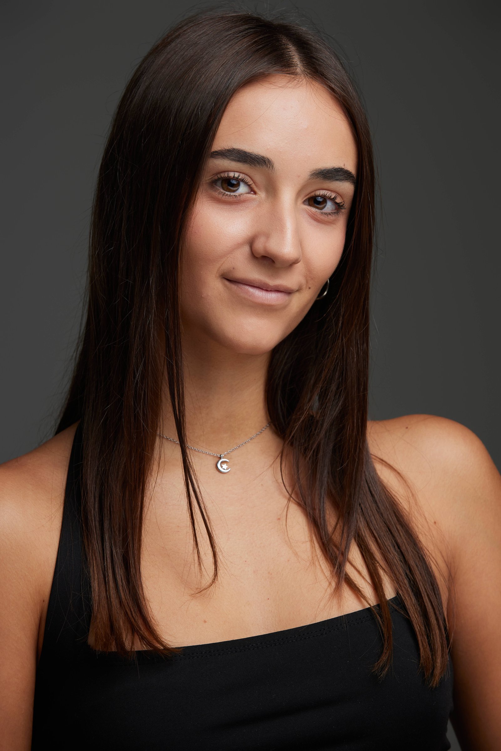 Retrato de Elena Maroto con luz suave y peinado suelto, fondo gris neutro