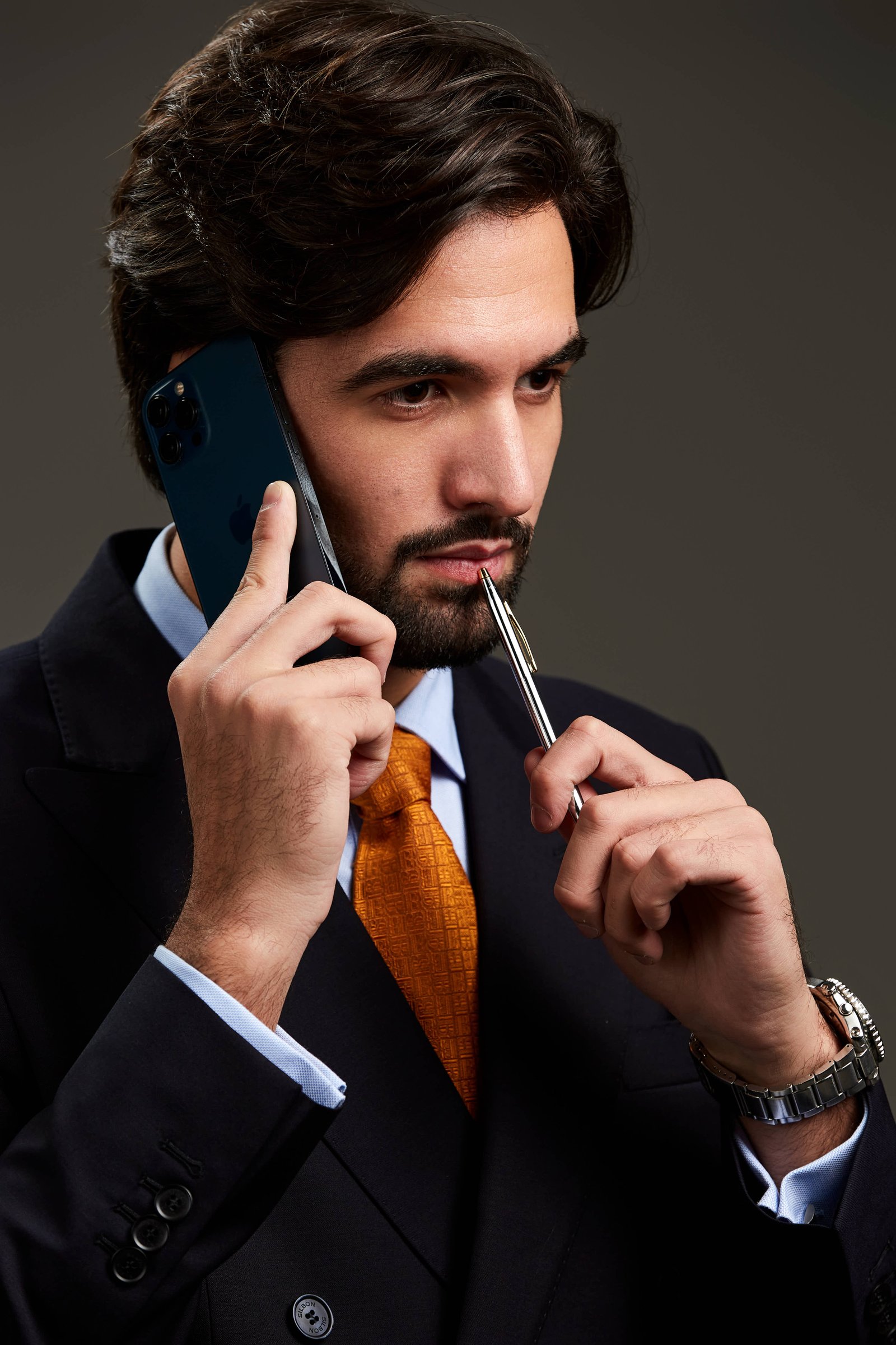 Fotografía corporativa de abogado con teléfono y pluma en estudio