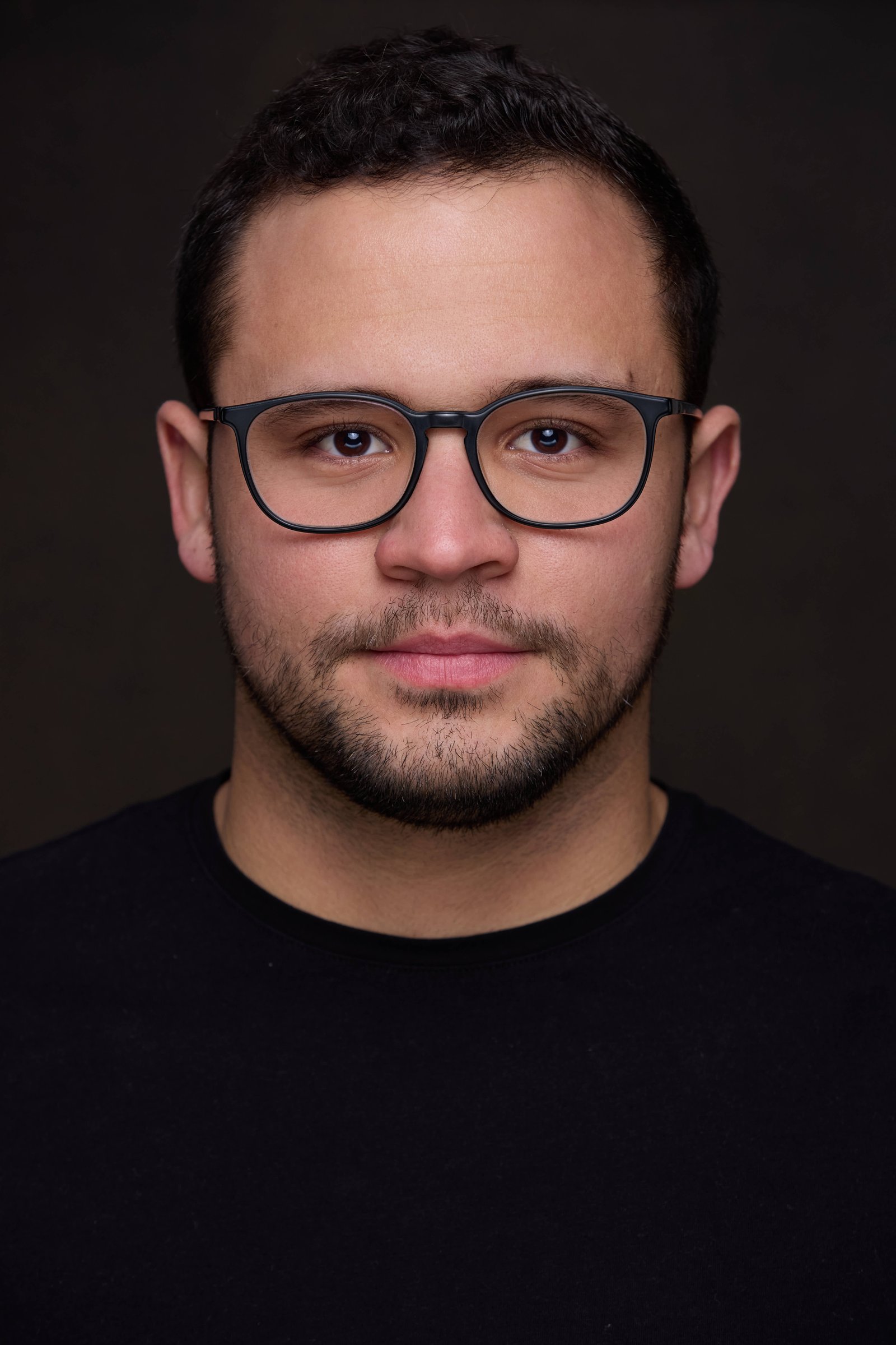 Retrato corporativo de Horacio con fondo gris oscuro, mirada natural y acabado profesional.